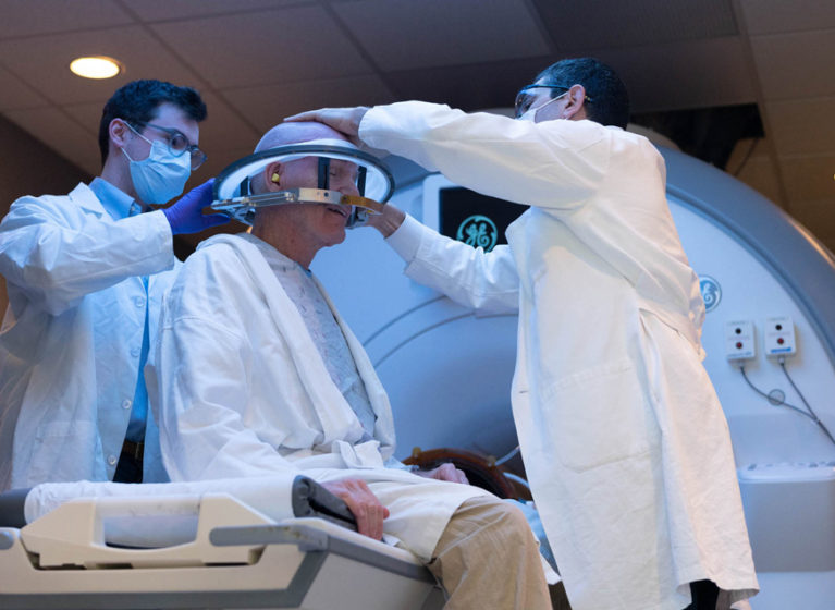 Two healthcare providers working with a patient who will receive focused ultrasound