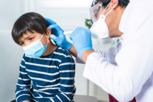 doctor examining child's ear