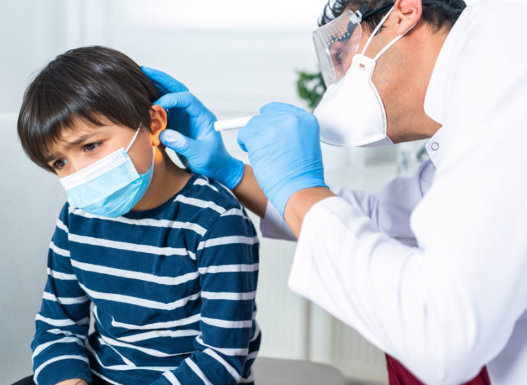 doctor examining child's ear