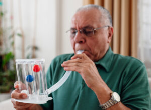 man blows into spirometer