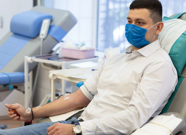 A patient wearing a mask and getting hemodialysis.