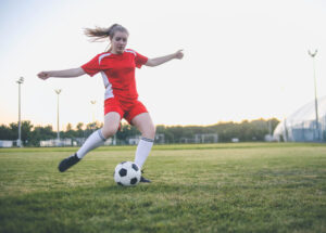 Girl playing soccer as part of school team